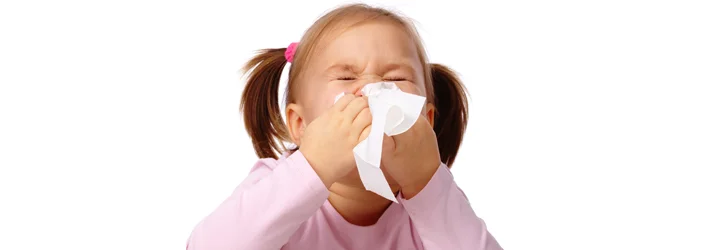 Chiropractic Livonia MI Allergy A young girl sneezing in to a tissue.