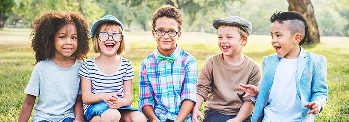 Five kids sitting outside smiling.