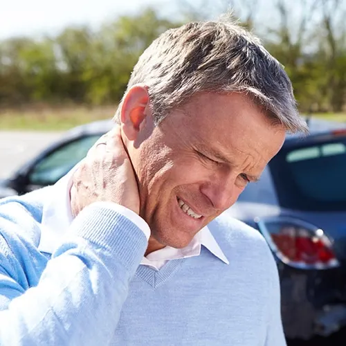 A man holding his neck in pain.